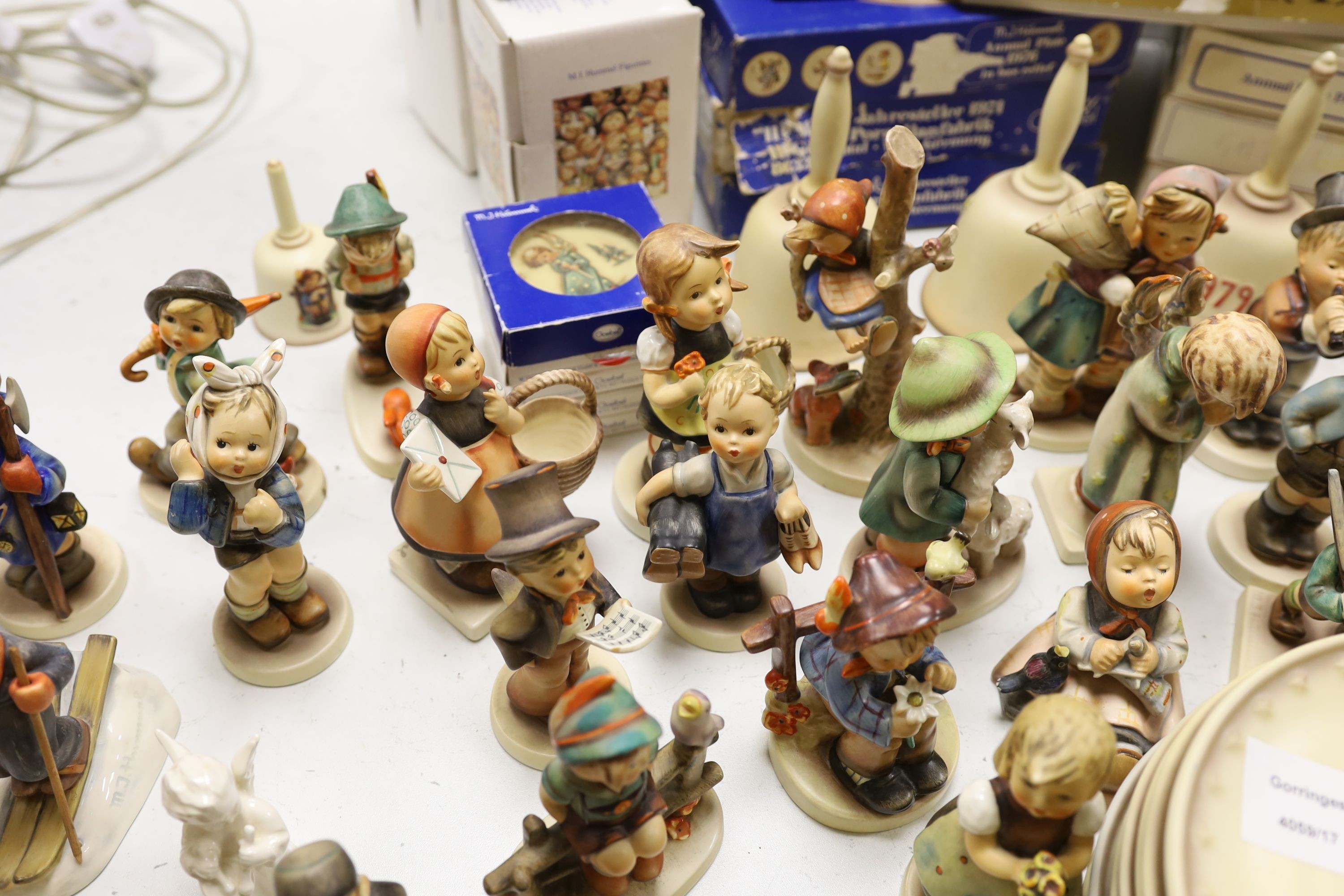 A large collection of Hummel pottery figures, approximately 70 including skier and two similar plaques, some with boxes.